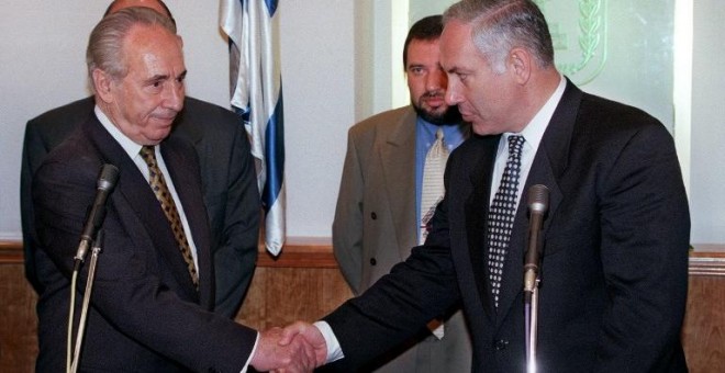 Benjamin Netanyahu y Shimon Peres se estrechan la mano en la ceremonia de traspaso de poderes al frente del Gobierno de Israel, en junio de 1996. AFP/Menahem Kahana