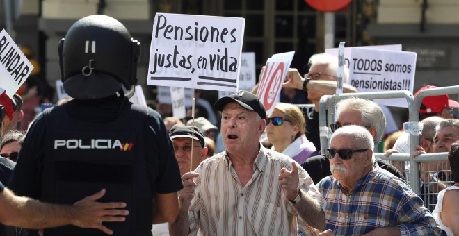 Grupos de pensionistas que se concentraron en el Congreso de los Diputados pidiendo mejoras en sus prestaciones intentan romper el cordón policial intentaba impedir su paso hasta la cámara donde hoy estaba prevista una reunión del Pacto de Toledo. EFE/Bal