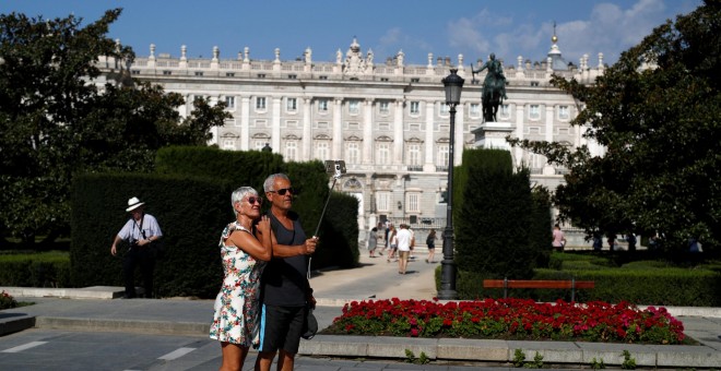Una pareja de turistas se toman un selfi cerca del Palacio Real de Madrid. REUTERS/Javier Barbancho