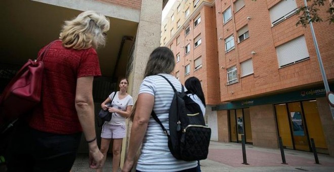 25/09/2018.- Un grupo de vecinos conversa en el lugar donde dos niñas de 2 y 6 años han sido asesinadas a cuchilladas en la ciudad de Castellón supuestamente por su padre, que posteriormente se ha suicidado arrojándose por la ventana de la vivienda, según