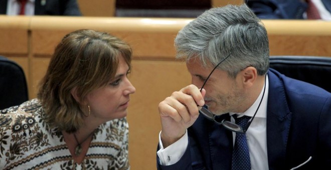 La ministra de Justicia, Dolores Delgado, conversa con el ministro del Interior, Fernando Grande-Marlaska, durante el pleno del Senado. EFE/Zipi