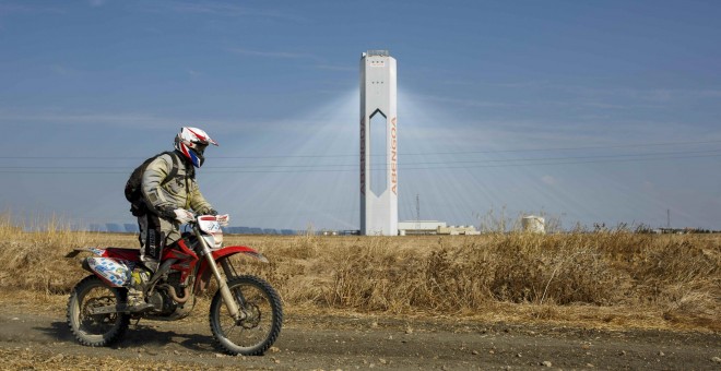 Un motocilcista pasa cerca de la torre de la planta solar 'Solúcar' de Abengoa, en la localidad sevillana de Sanlucar la Mayor. REUTERS/Marcelo del Pozo