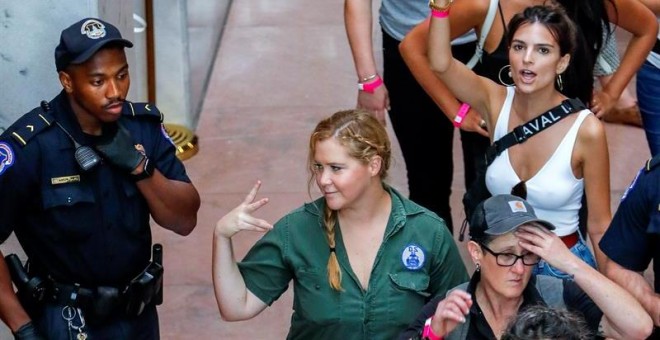 La actriz Amy Schumer y la modelo Emily Ratajkowski gesticulan después de ser detenidas junto con cientos de otros manifestantes. - EFE