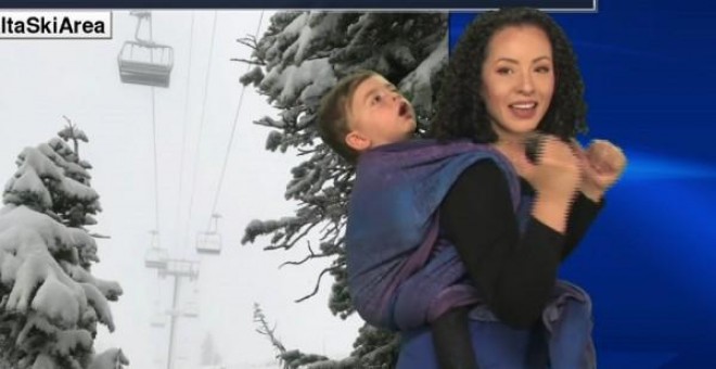 La presentadora Susan Martin con su hijo a la espalda dando el parte meteorológico. Fuente: facebook.
