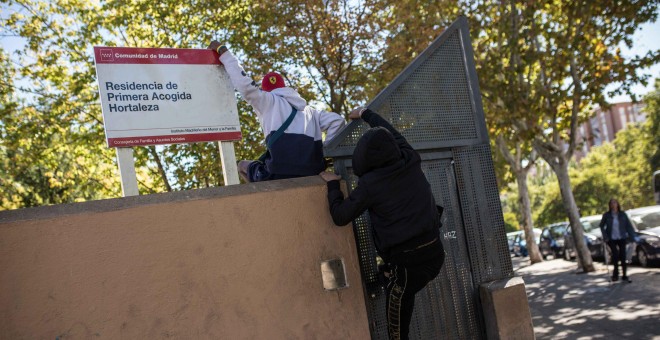 Dos menores migrantes saltan el muro para acceder al Centro de Primera Acogida de Menores de Hortaleza, en Madrid.- JAIRO VARGAS
