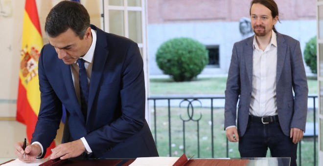 El presidente del Gobierno, Pedro Sánchez, y el secretario general de Podemos, Pablo Iglesias, firman en el Palacio de la Moncloa del acuerdo sobre el proyecto de ley de presupuestos para 2019. EFE/ Zipi