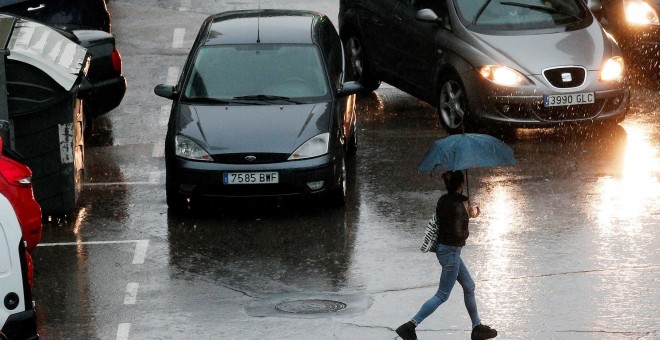 Una persona se protege de la lluvia con un paraguas durante la mañana de este viernes en la que el cielo de la Comunidad Valenciana permanece cubierto con precipitaciones fuertes o muy fuertes, sobre todo en Castellón y Valencia - EFE/Kai Försterling