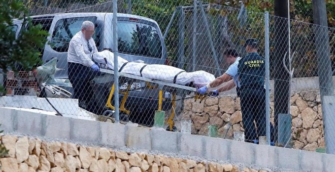 Miembros de los servicios funerarios trasladan el cuerpo de una de las víctimas de Finestrat.   EFE