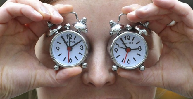 Imagen de archivo de una mujer con dos relojes con el cambio de hora. EFE/Andras Gebert