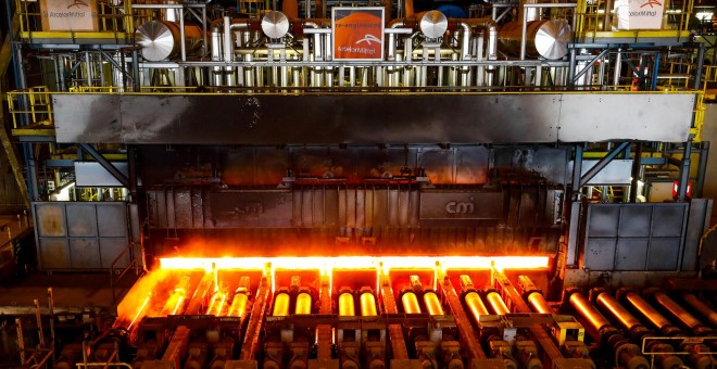 Una placa de acero al rojo vivo pasa a través de una prensa en la planta de ArcelorMittal en Gante, Bélgica. REUTERS / Yves Herman