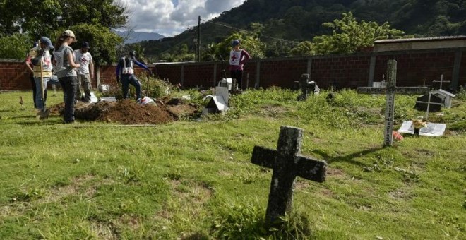 Miembros del Comité Internacional de la Cruz Roja (CICR) trabajan en la recuperación de los restos mortales de asesinados durante el conflicto armado en Colombiam en un cementerio en la jungla del Catatumbo. - AFP