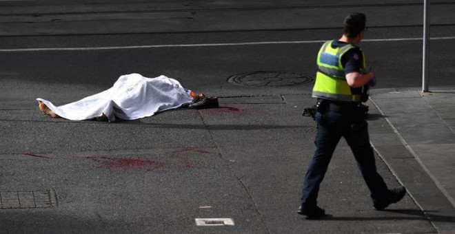 09/11/2018.- El cadáver de una víctima yace sobre el asfalto después de que un hombre armado con un cuchillo atacase a varias personas en la calle Bourke de Melbourne (Australia), hoy, 9 de noviembre de 2018. Una persona murió y otras dos se encuentran ho