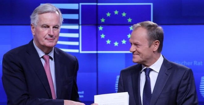 Michel Barnier entrega el borrador del acuerdo del brexit a Donald Tusk en Bruselas. / EFE