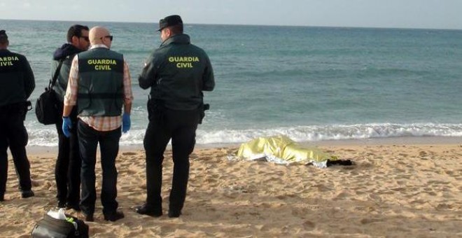 Agentes de la Guardia Civil junto al cadáver hallado este viernes en las inmediaciones de la playa del Faro de Trafalgar (Cádiz) que eleva a 20 el número de víctimas mortales del naufragio de la patera ocurrido el pasado 5 de noviembre en la playa gaditan