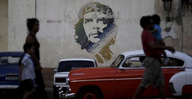 16/03/2016. Unas personas pasan por delante de una pintura del Che Guevara en La Habana. REUTERS/Ueslei Marcelino