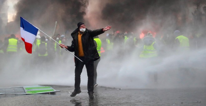 Un manifestante sostiene una bandera francesa durante los enfrentamientos entre los 'chalecos amarillos' y la policía en París.- REUTERS/Gonzalo Fuentes