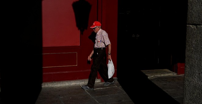 Un pensionista camina por una calle del centro de Madrid. REUTERS/Juan Medina