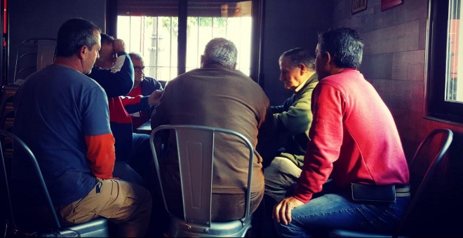 Unos pensionistas pasan su tiempo libre jugando al dominó en un bar del pueblo.