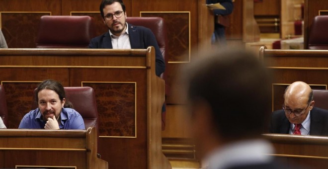 El líder de Unidos Podemos, Pablo Iglesias, en su escaño, escucha la respuesta del presidente del Gobierno en una sesión de control al Gobierno. E.P.