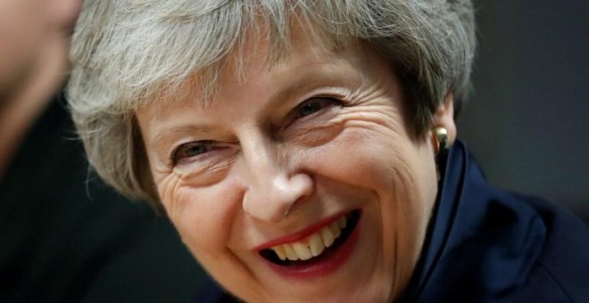 La primera ministra británica, Theresa May, reacciona durante su visita al Scottish Leather Group Limited en Bridge of Weir en Escocia el 28 de noviembre de 2018 | AFP