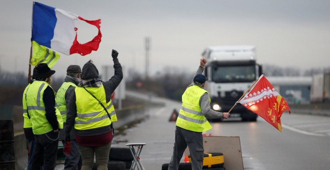 Miembros del movimiento de los chalecos amarillos, el símbolo de una protesta de los conductores franceses contra los altos precios del combustible diesel, ocupan una rotonda en Roppenheim, Francia. REUTERS / Vincent Kessler
