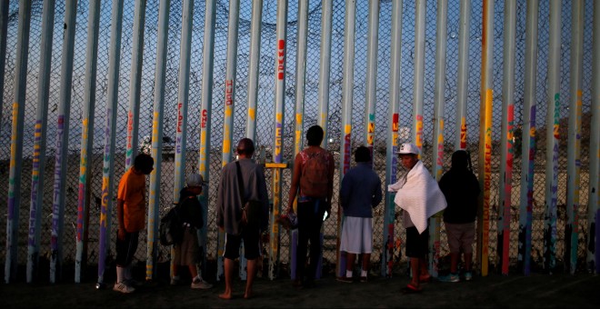 Un grupo de migrantes centroamericanos observa el muro fronterizo entre México y EEUU.- REUTERS/Mohammed Salem