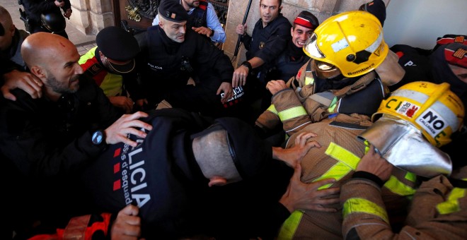 Enfrentamiento entre bomberos catalanes y agentes de los Mossos d'Esquadra a las puertas del Parlament, en las protestas de finales de noviembre. REUTERS/Albert Gea