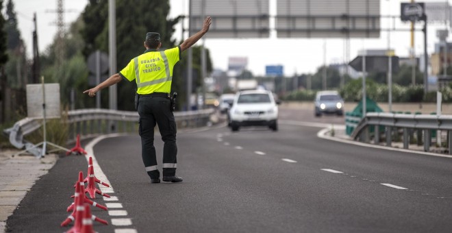 Un agente de la Guardia Civil de Tráfico da el alto a un conductor en un control, con motivo de la campaña puesta en marcha por la DGT sobre control de la tasa de alcohol y presencia de drogas en conductores | EFE