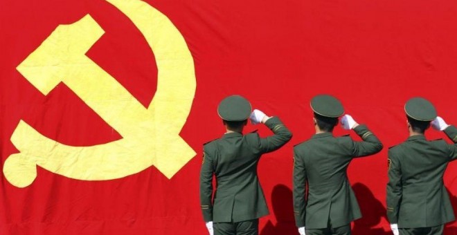 Policías paramilitares levantan sus puños frente a una bandera del Partido Comunista de China antes del XVIII Congreso Nacional del Partido Comunista de China, en una base militar en Hangzhou, en 2012. REUTERS / China Daily