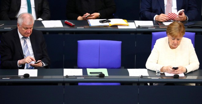Fotografía de archivo de la canciller alemana Angela Merkel y el ministro del Interior, Horst Seehofer, usando sus móviles en el Bundestag. /REUTERS