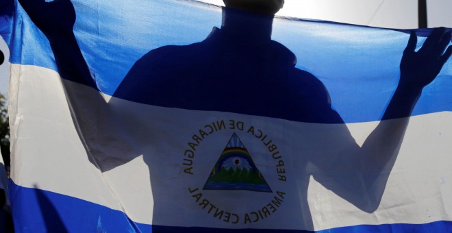Un manifestante sujeta la bandera de Nicaragua./REUTERS