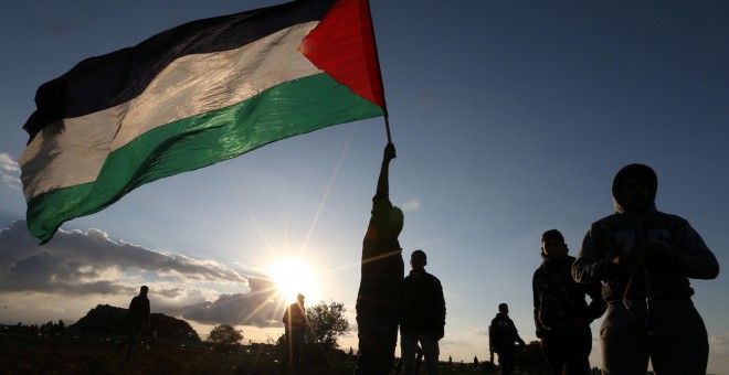 Manifestantes despliegan una bandera de Palestina durante una protesta junto a la frontera en Gaza. - REUTERS
