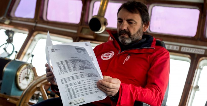 El fundador de la ONG Open Arms, Oscar Camps , lee el despacho enviado por el Ministerio de Fomento, que les deniega el permiso para zarpar hacia el Mediterráneo.EFE/ Quique García