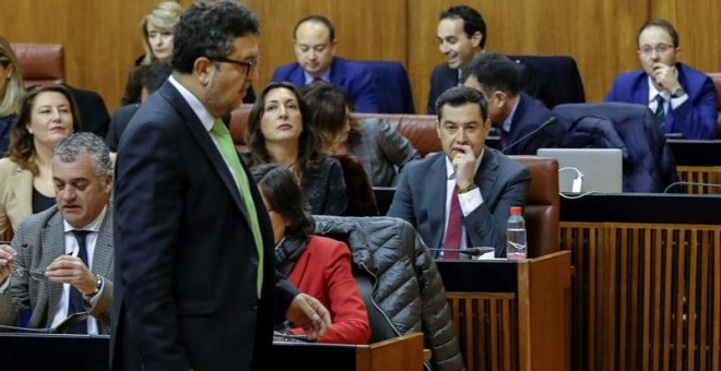 El líder de Vox en Andalucía, Francisco Serrano, pasa ante el candidato Juanma Moreno (c-d), en el Parlamento de Andalucía. - EFE