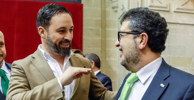 El líder nacional de Vox, Santiago Abascal, y el diputado de esa formación, el juez Francisco Serrano, conversando al inicio de la segunda jornada del debate de investidura del presidente del PP andaluz, Juanma Moreno, en el Parlamento andaluz en Sevilla.