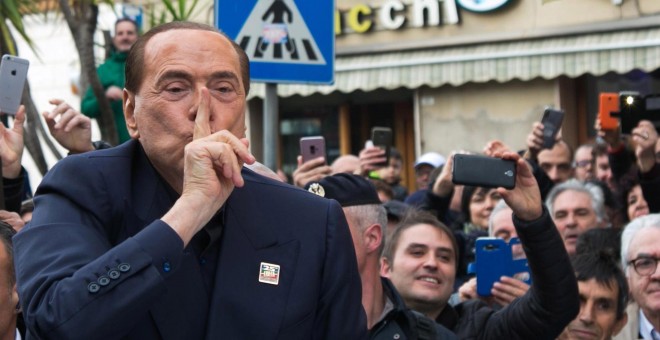 El ex primer ministro italiano Silvio Berlusconi saluda a su simpatizantes durante su visita este viernes a Cerdeña, un día después de anunciar su candidatura a las elecciones europeas de mayo, una decisión que toma a sus 82 años y con su partido en horas