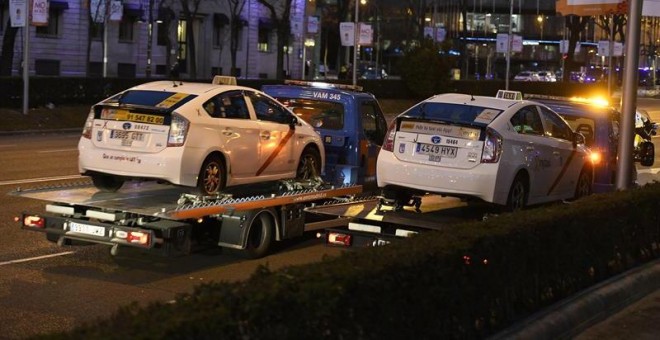 Dos grúas municipales retiran taxis del Paseo de la Castellana de Madrid. - EFE