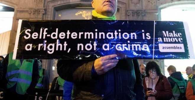 Una bandera europea con un crespón negro y una pancarta en inglés con el lema 'La autodeterminación es un derecho, no un crimen', que los activistas de la ANC han colocado en el balcón de la sede de la Comisión Europea en Barcelona. EFE/ Enric Fontcuberta