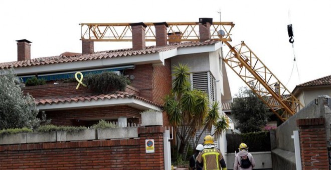 10/02/2019.- Bomberos en las inmediaciones del lugar en el que un operario ha fallecido y otro ha resultado herido menos grave al caer este domingo una grúa de construcción sobre un edificio en Sant Just Desvern (Barcelona). EFE/Toni Albir