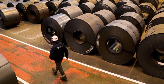 Un trabajador pasa junto a los rollos de acero de la planta de ArcelorMittal en Sestao. REUTERS