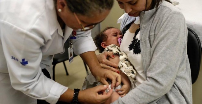 Una niña mientras es vacunada, en una imagen de archivo. / EFE