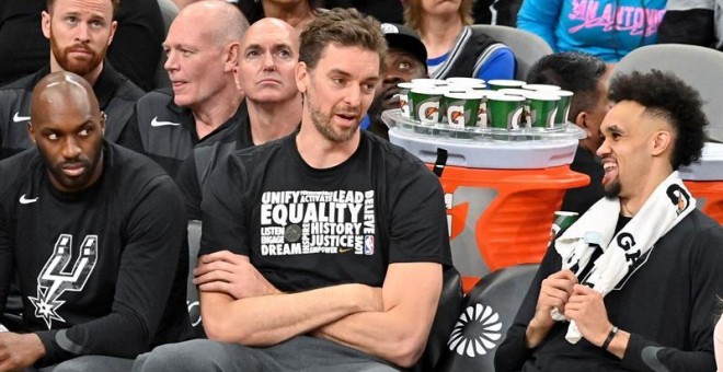 Los jugadores Pau Gasol (C) y Derrick White (d) de San Antonio Spurs conversan este miércoles durante un juego de baloncesto de la NBA ante Detroit Pistons, en San Antonio, Texas (EE. UU.). EFE/ Darren Abate