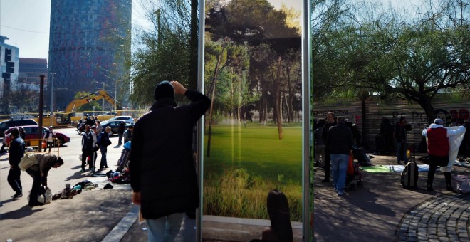 Un vendedor con la torre Agbar al fondo. - JORGE GARCÍA LÓPEZ