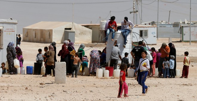 Refugiados sirios recogen agua en el campamento de Al-Zaatari en Mafraq, Jordania, cerca de la frontera con Siria. REUTERS / Muhammad Hamed