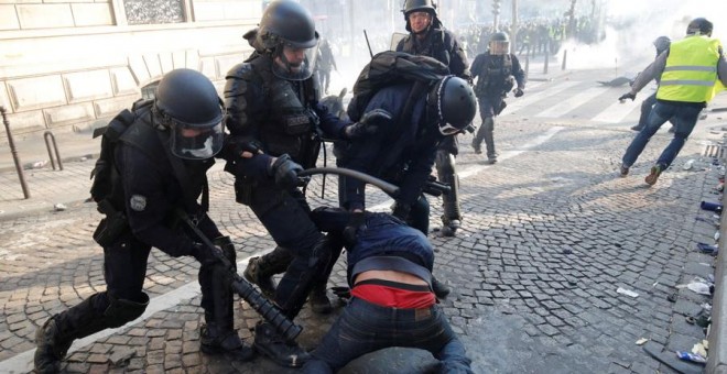 La Policía francesa golpea a un manifestante durante las protestas de los chalecos amarillos. REUTERS/Philippe Wojazer