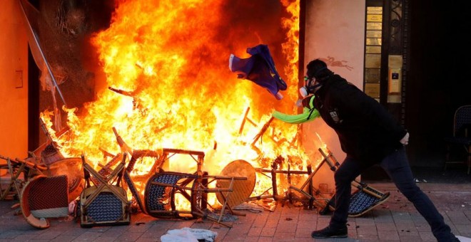 Un manifestante tira una bandera de la UE a un incendio en París durante las protestas de los chalecos amarillos de este sábado. REUTERS/Philippe Wojazer