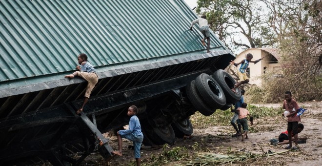 Unos niños juegan en un contenedor volcado por el ciclón Idai en Beira, Mozambique, el 21 de marzo de 2019  | AFP/ Yasuyoshi Chiba