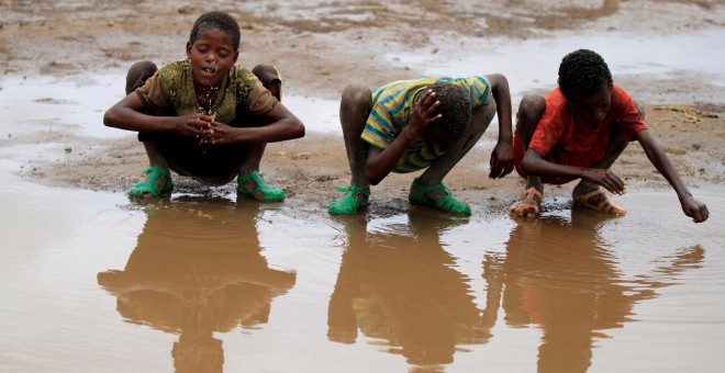 Varios niños se lavan en un charco en la ciudad de Kobo, Etiopía. - REUTERS