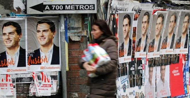 Una mujer pasa por una calle con los carteles de Albert Rivera.- EFE