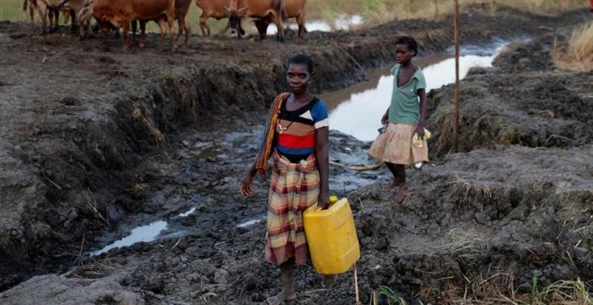 Varias mujeres desplazadas tras el paso del ciclón Idai recogen agua en Sofala. EFE